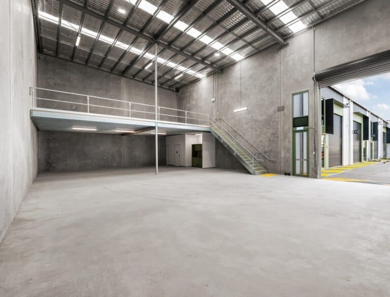 Spacious industrial warehouse with mezzanine and large roller doors.