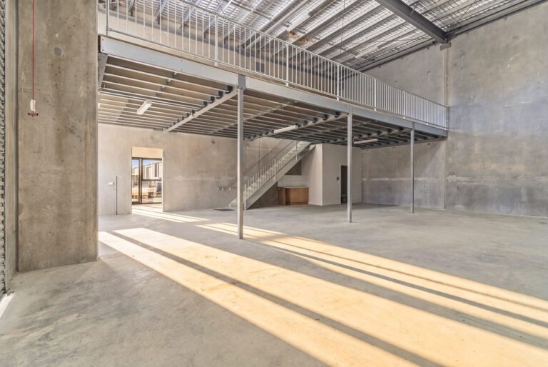 Spacious industrial warehouse with mezzanine and concrete floors.